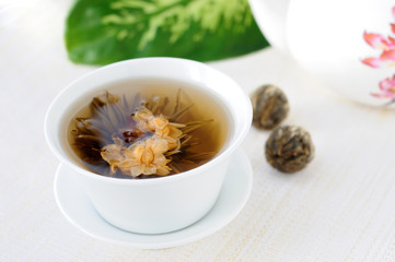 Tied green tea blossoms in a tea cup
