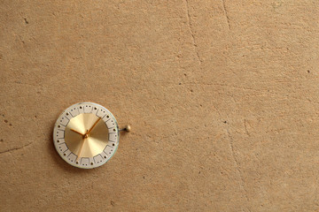 Old rusty watch dial on textured wall background