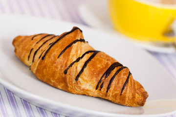 Cappuccino mit Croissant mit Schoko-Überzug