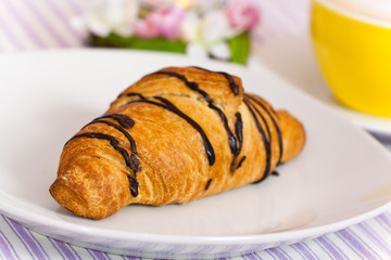 Cappuccino mit Croissant mit Schoko-Überzug