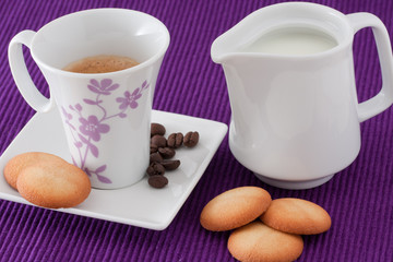 an elegant cup of coffee with milk and  biscuits
