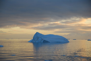 blue iceberg in sunset