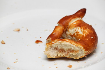 Angebissene Brezel auf Teller