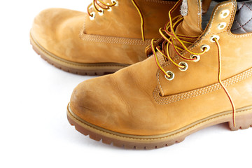 Pair of old yellow working boots Isolated on white background