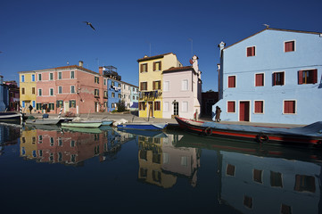 Fototapeta na wymiar Burano, case tipiche riflettono sul canale