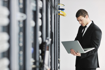 businessman with laptop in network server room