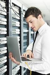 businessman with laptop in network server room