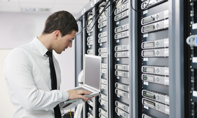 businessman with laptop in network server room - obrazy, fototapety, plakaty