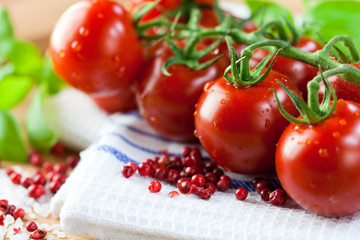 Fresh cherry tomatoes and pink peppercorns on a kitchen towel