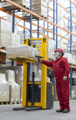 Senior worker in red uniform with bar code reader in warehouse