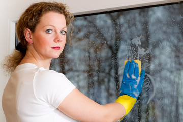 ernster blick beim fensterputzen