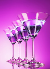 Four martini glasses on purple background