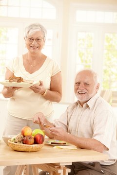 Portrait of happy senior couple at breakfast