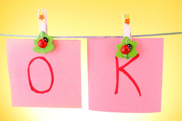 Blank paper sheet on a clothes line against the yellow backgroun