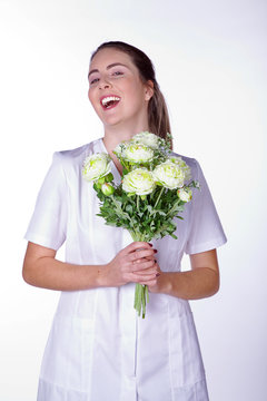 Krankenschwester bringt lachend Blumenstrauss