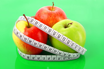 White tape measure around a red apple representing dieting