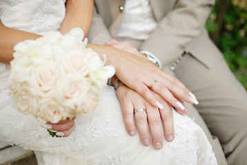 Obraz na płótnie Canvas Bride and groom holding each others hands