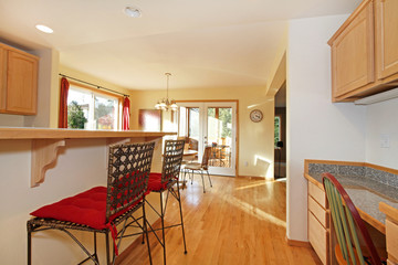 Sunny yellow kitchen with red stools at the bar