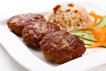 Fried steaks with rice and vegetable salad