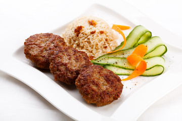 Fried steaks with rice and vegetable salad