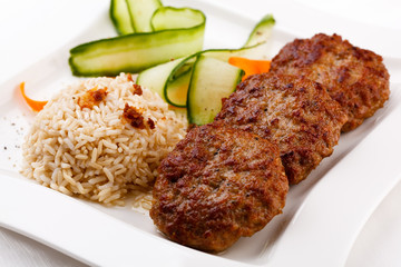 Fried steaks with rice and vegetable salad