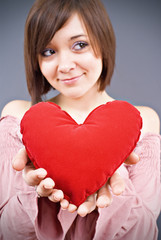 Young happy smiling woman with heart symbol, isolated