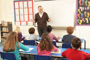 Schoolchildren Studying In Classroom With Teacher