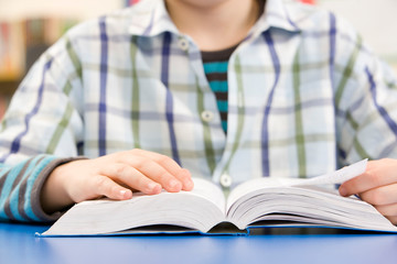 Close Up Of Schoolboy Studying Textbook In Classroom