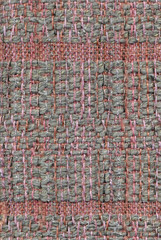 Close up detail of handwoven, patterned fabric in pink and gray