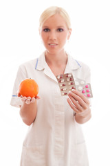 Blond nurse or doctor holding orange and pills