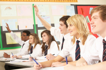 Teenage Student Answering Question Studying In Classroom
