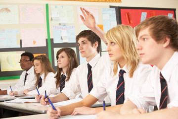 Teenage Student Answering Question Studying In Classroom