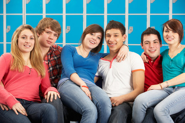 Teenage Students Relaxing By Lockers In School