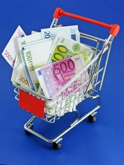 Euro currency in a shopping trolley on blue background