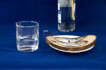 Glass of vodka and sandwich with a sprat