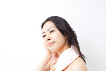 タオルで顔を拭く女性