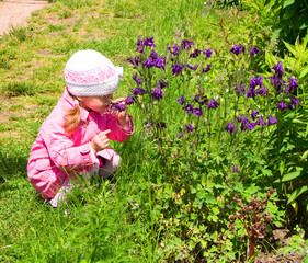 Little girl smells the wild flowers