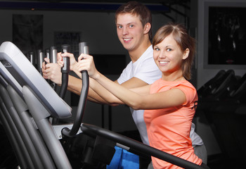 Fototapeta premium Young couple on exercise bicycle