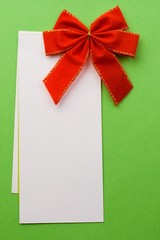 Red bow with card isolated on green
