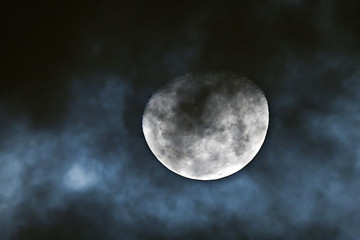 Waning gibbous moon behind the clouds