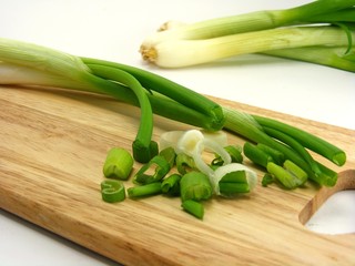 Spring onions on a wooden chopping board