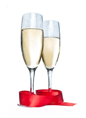 Glasses with Champagne and red ribbon isolated on white
