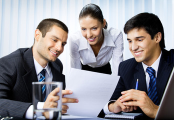 Three businesspeople working with document at office