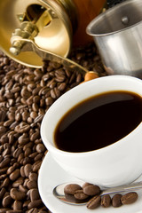 cup of coffee and grinder on beans