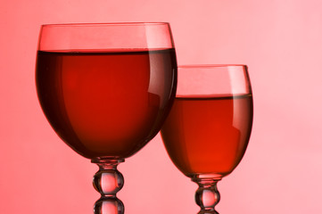 Wine glasses with wine on a pink background