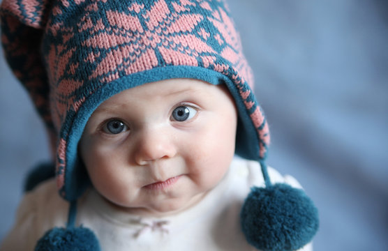 Baby with blue eyes in a winter cap