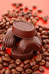 Chocolate and coffee beans on red background