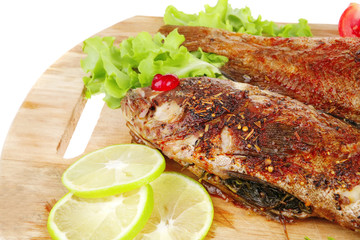 roasted sea fish on wood with tomatoes