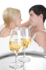 Young couple drinking champagne in bed