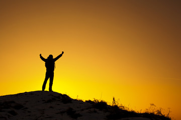 Szczęśliwy mężczyzna na szczycie góry o zachodzie słońca - obrazy, fototapety, plakaty